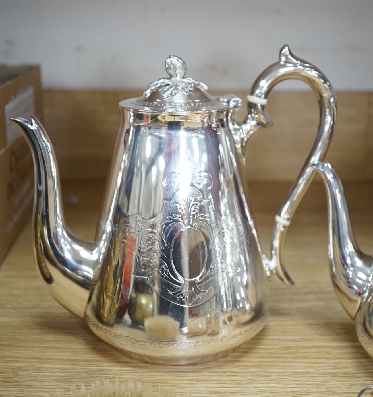 An Art Deco three piece silver brush set and a silver plated three piece tea set and miniature caldron, coffee pot 22cm high. Condition - fair